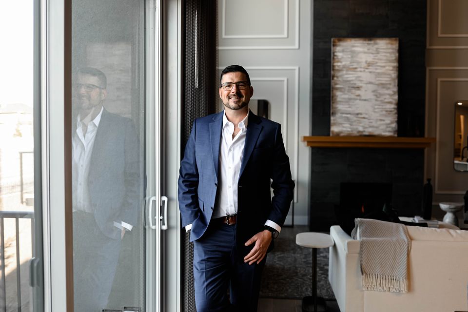 Ezra Malo, Calgary REALTOR® at RE/MAX First, in a bright living room beside the patio doors